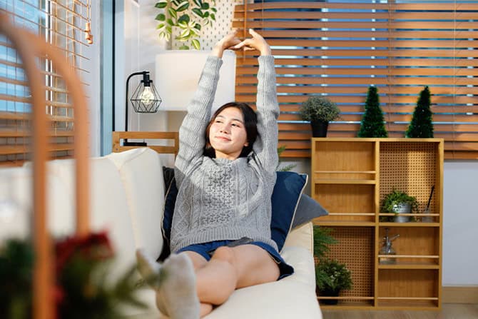 Happy asian woman relaxing on the sofa at home, Smiling girl enjoying day off lying on the couch