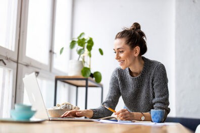 Woman working on her computer at her desk.
