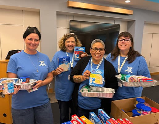 Group of colleagues assembling birthday cake kits.