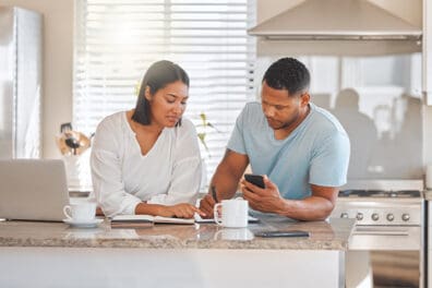 Shot of a couple going over paperwork together at home.