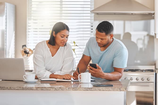 Shot of a couple going over paperwork together at home.