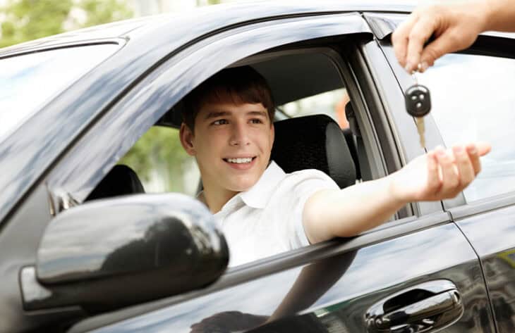Young man being handed the keys to his new car.