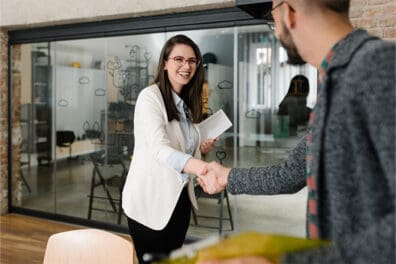 Professional women greeting a customer coming into office.