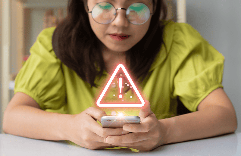 Women on cell phone with warning sign.